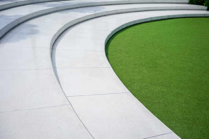 Green grass with white concrete stairs for nature theme decoration concept. Outdoor amphitheater.